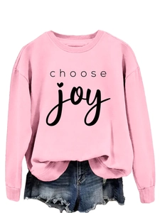 Close-up of pink crewneck sweatshirt featuring black Choose Joy slogan printing