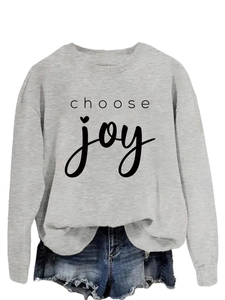 Flat lay of gray crewneck sweatshirt with choose joy print and distressed denim shorts