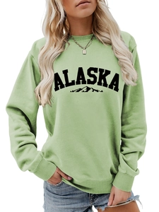 Detail of sage green Alaska sweatshirt showing ribbed cuffs and mountain graphic print