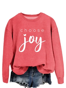 Close-up of a red round-neck sweatshirt with 'choose joy' print and frayed denim shorts