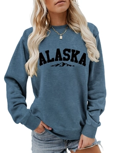 Close-up of blue ALASKA sweatshirt with mountain print and ribbed crew neck details