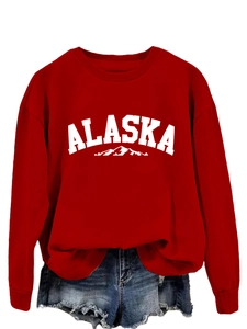 Detail of red crewneck sweatshirt featuring white Alaska lettering and mountain graphic