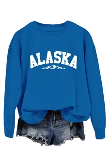 Flat lay of blue Alaska crewneck sweatshirt with ribbed cuffs and denim shorts