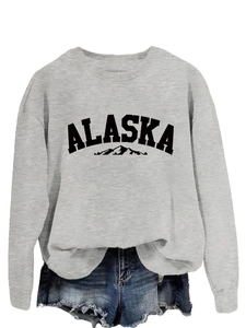 Close-up of Alaska mountain print on gray crewneck sweatshirt with denim shorts