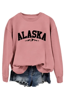 Close-up of pink crewneck Alaska sweatshirt paired with distressed blue denim shorts