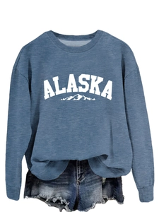 Detail of blue Alaska crewneck sweatshirt tucked into denim shorts on white background