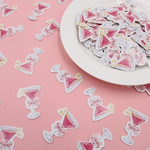 Dettaglio di coriandoli in carta a forma di martini rosa con fiocco e limone