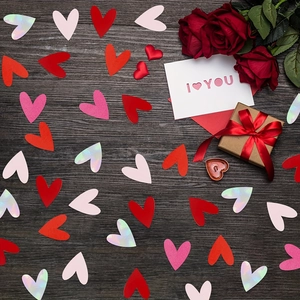 Pink and red heart confetti set with roses, gift box and I Love You card on wood