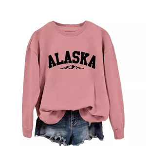 Pink crewneck sweatshirt with Alaska mountain print paired with denim shorts