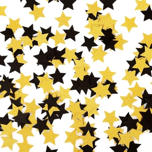 Detalle de confeti de estrellas doradas brillantes y negras mates para mesa festiva