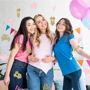 Baby shower party decoration featuring golden glitter Oh Baby sign and infant bodysuit confetti