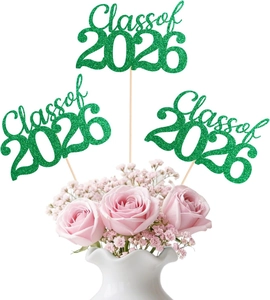 Glittery green Class of 2026 cake toppers inserted in a bouquet of pink roses