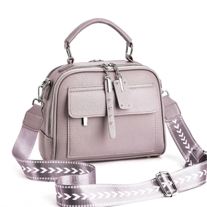 Détail d'un sac à main mauve en similicuir grainé avec une large bandoulière géométrique