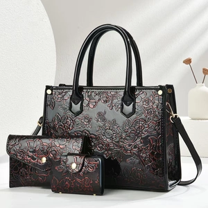 Detailed relief of rose patterns on black luxury 3-piece tote bag set with gold hardware
