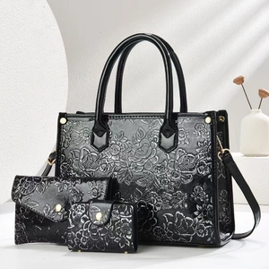 Detailed macro view of black embossed floral pattern on luxury faux leather 3-piece bag set