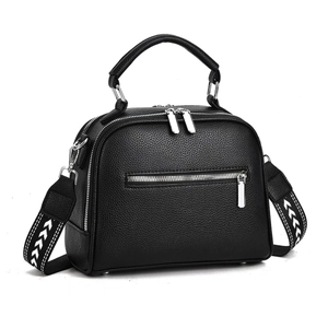 Detail of black pebbled leather crossbody bag with patterned wide fabric strap