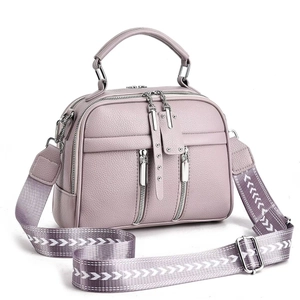 Detail of lavender lychee leather crossbody bag with silver zippers and wide patterned strap