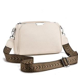 Detail of beige pebble leather crossbody bag featuring a wide geometric woven strap