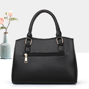 Detail of black faux leather tote bag with gold zipper and stylish handle design