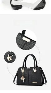 Detail of the crocodile pattern on black faux leather Boston handbag with gold hardware