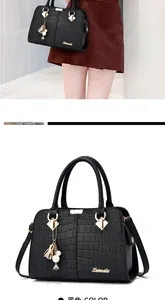 Detail of black faux leather tote with crocodile texture and gold hardware accents
