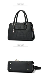 Detail view of black crocodile pattern handbag showing side angles and metal feet