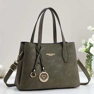 Gros plan du sac cabas en cuir grainé vert olive avec détails en métal doré