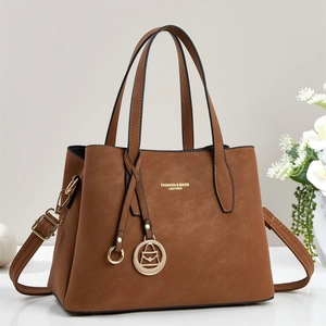 Détail du sac cabas en cuir marron avec dorures et bandoulière amovible
