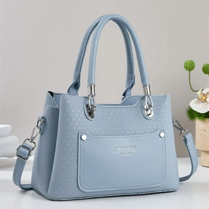 Détail du sac à main bleu clair avec texture tressée, anneaux argentés et poignées