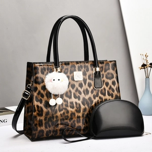 Detail of leopard print tote bag with swan logo and black lacquer mini clutch set
