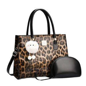 Leopard print large tote bag with black clutch and swan logo on white background