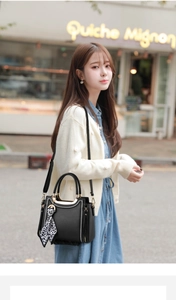 Chic black leather handbag featuring contrast stitching and leopard print silk scarf