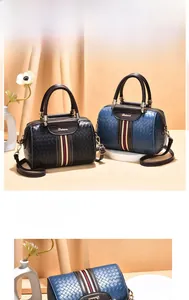 Detail of woven Boston handbag with contrast stripes, leather handles and brand logo