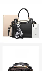 Detail view of the black handbag interior compartments and size comparison with a 9.7-inch tablet