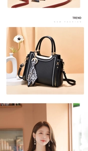 Detail of black crossbody bag with white stitching and leopard print silk scarf