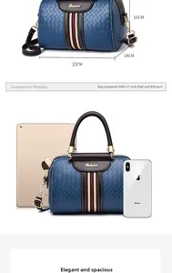 Detailed view of blue woven Boston bag with dimensions 23cm by 14cm by 16cm and brown handles