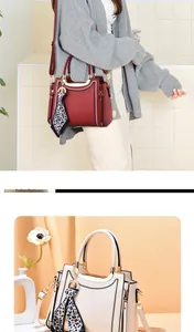 Detail view of stylish crossbody bags in red and off-white with silk scarf accessories