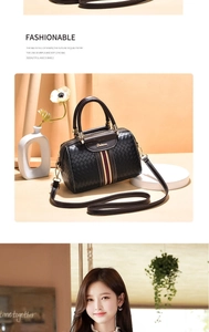 Detail of black woven texture bag with red and blue stripes and gold brand logo