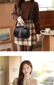 Detailed view of black woven texture Boston bag with signature striped ribbon detail
