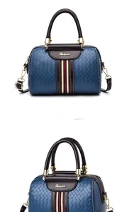 Detailed view of dark blue woven texture handbag featuring classic red and blue webbing