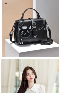 Detail of black leather cat-shaped charm on a minimalist crossbody small square bag