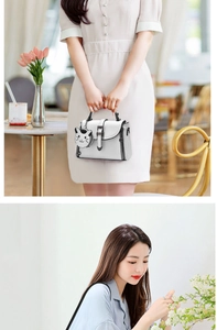 Detail of white mini crossbody bag with black contrast piping and cute cat charm
