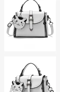 Front detail of white leather handbag with vertical zippers and cute cat charm attachment