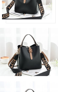 Detail of black bucket bag with brown handles and a patterned wide shoulder strap