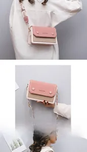 Détail du sac à bandoulière bicolore en similicuir rose avec large bandoulière tissée