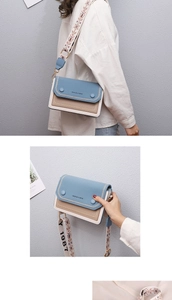 Détail du sac bandoulière bicolore avec bandoulière brodée et cuir bleu mat