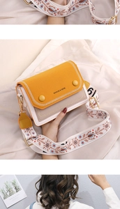 Détails du mini sac bandoulière bicolore avec sangle brodée et finitions tressées