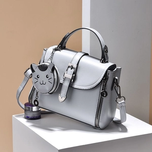 Silver PU leather crossbody cat bag with cute kitten charm on white stone base