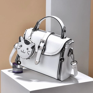 White minimalist PU leather handbag with cute cat pendant on geometric stage display