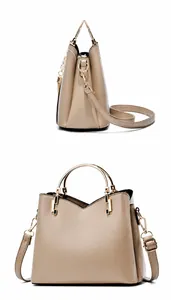 Detail view of khaki patchwork handbag featuring gold circular handles and pearl tassel charm